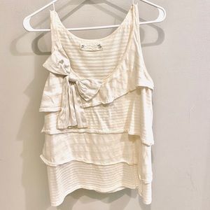 Sleeveless top with silk bow application in front.